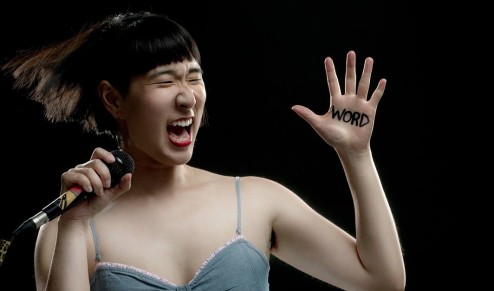 Woman with microphone yelling with Word written on hand