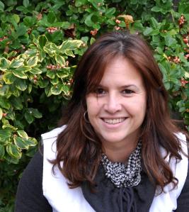 Woman with white vest in front of a bush