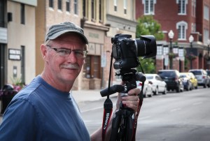 Man with camera and tripod on street