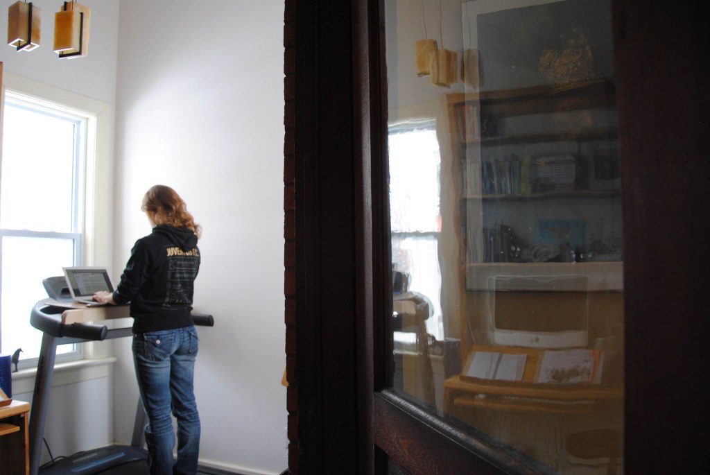 woman working on her laptop on treadmill