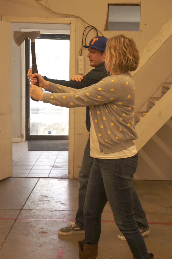 Woman learning to thrown an axe