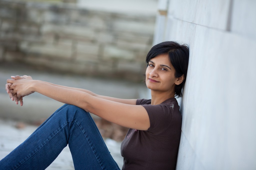 Canadian writer Tasneem Jamal sittingagainst a wall