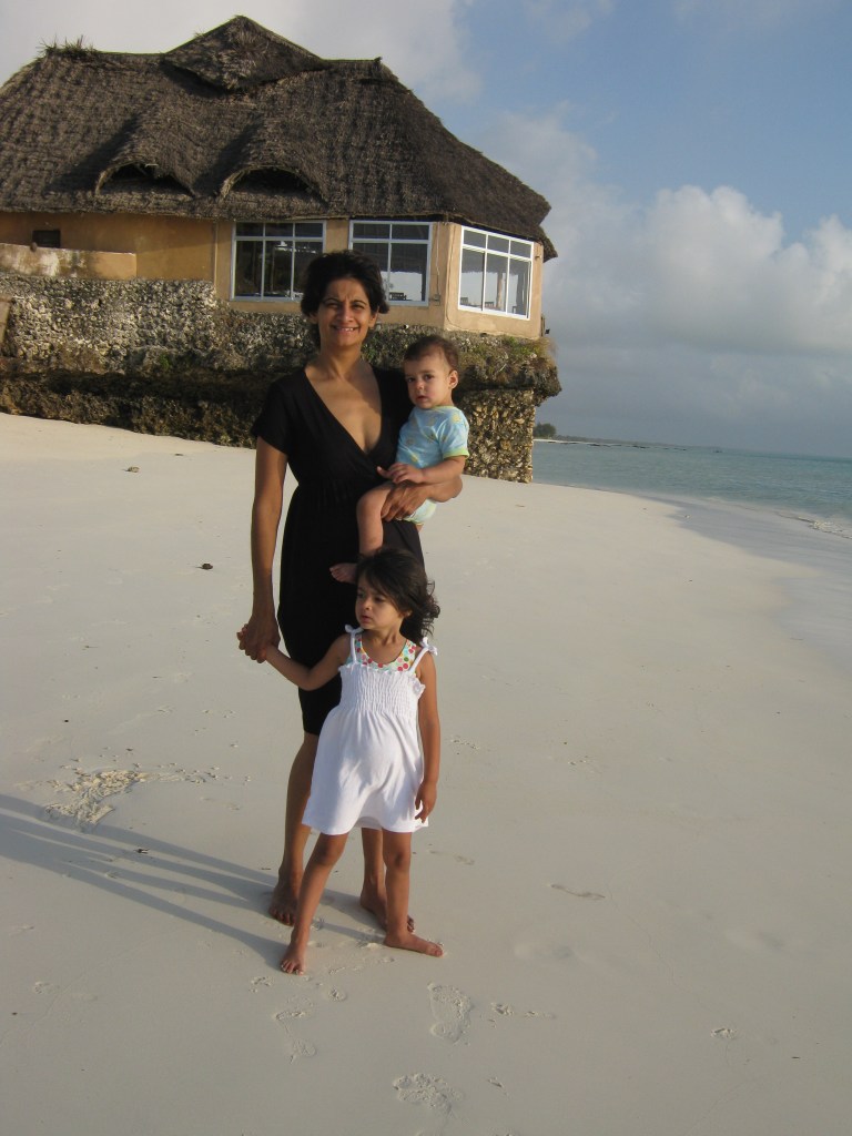 Woman with two daughters on African beach