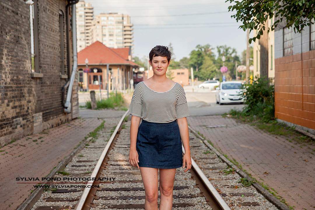 Woman standing on railroad tracks